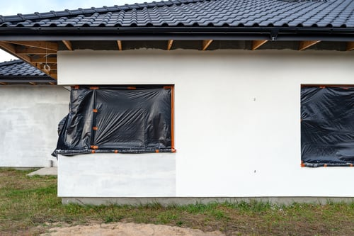 Windows masked off and siding prepped before exterior painting